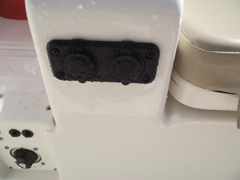 Slide: The Image of 2025 Bayliner Trophy T22SC boat console with dual socket panel and cushioned seat. - 34