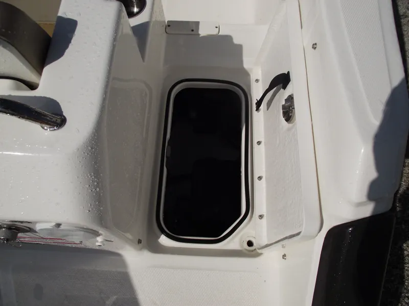Slide: The Image of 2025 Bayliner Trophy T22SC boat storage compartment, open lid, white interior. - 40