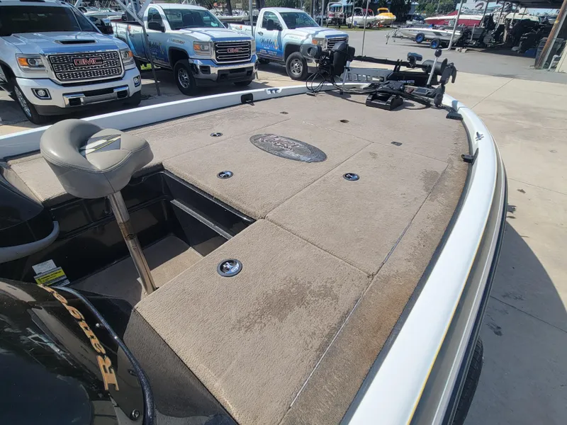 Slide: The Image of 2003 Ranger 521VX NASCAR boat with fishing deck, parked near trucks. - 16