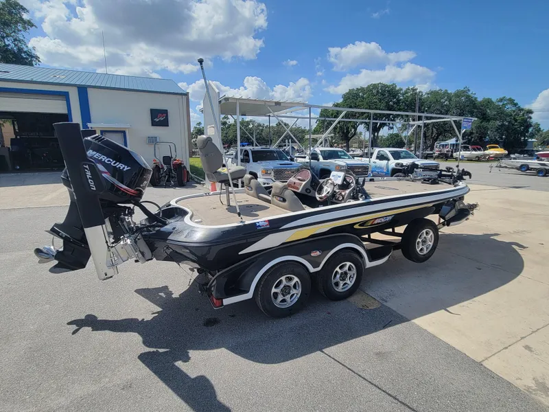 Slide: The Image of 2003 Ranger 521VX NASCAR boat with Mercury engine, parked outdoors under a blue sky. - 4