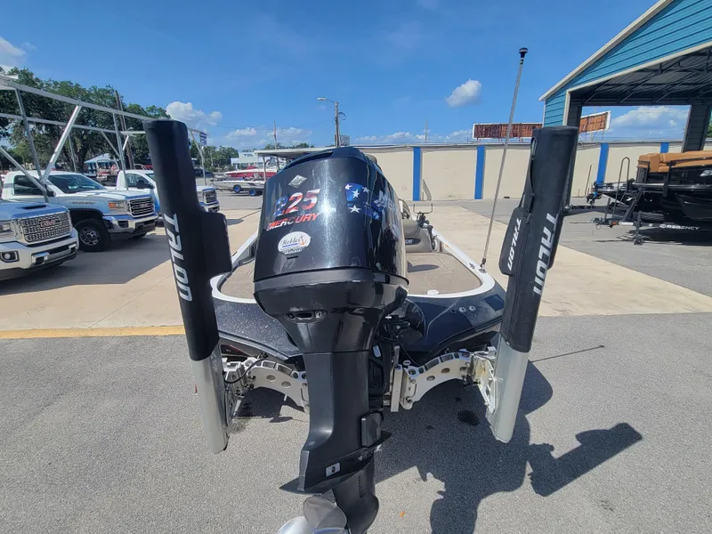 Slide: The Image of 2003 Ranger 521VX NASCAR boat with outboard motor, parked outdoors on a sunny day. - 5