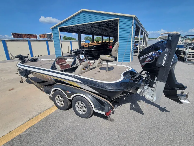 Slide: The Image of 2003 Ranger 521VX NASCAR boat with Mercury engine parked near blue storage building. - 6