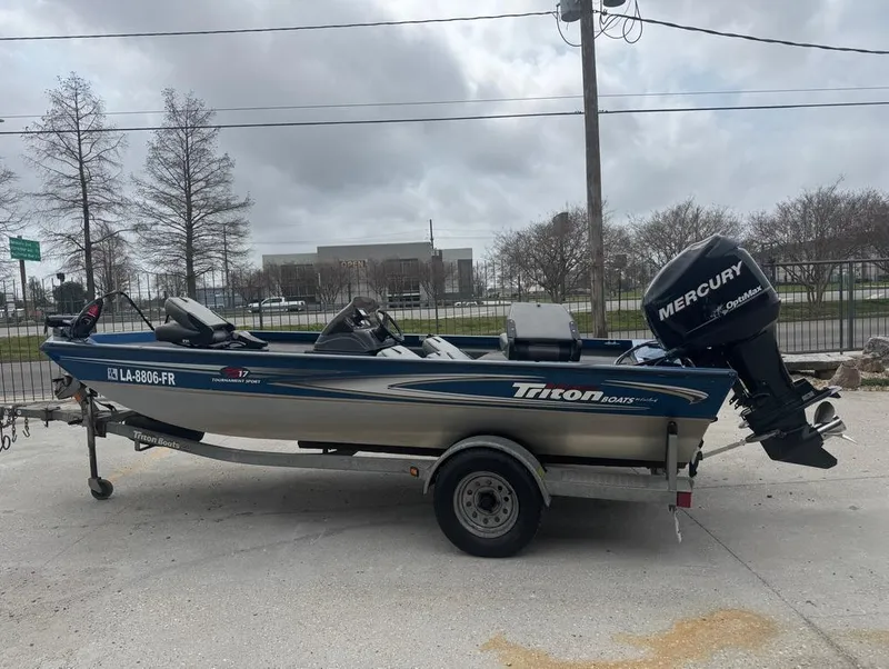 Slide: The Image of 2007 Triton TS 17 boat with Mercury outboard motor on trailer, parked outdoors. - 2
