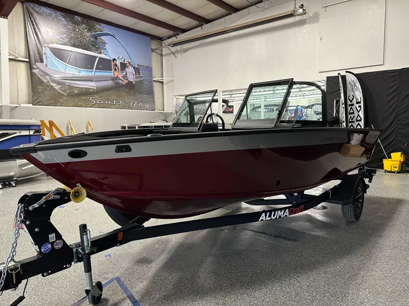 Slide: The Image of 2025 Alumacraft Competitor 185X Sport boat in showroom, red exterior, on trailer. - 3