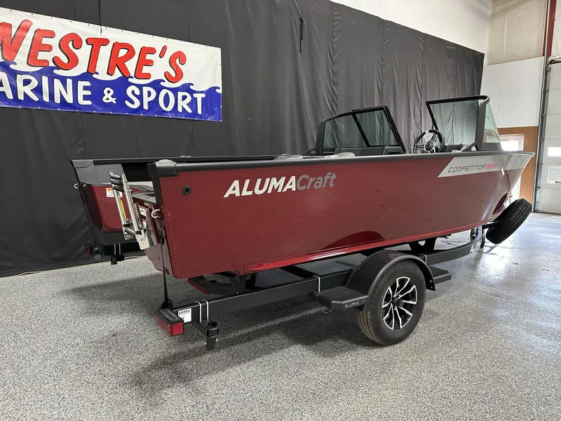 Slide: The Image of 2025 Alumacraft Competitor 185X Sport boat in showroom, rear view with banners. - 5