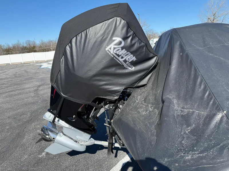 Slide: The Image of 2022 Ranger Z518 boat covered, parked outdoors on a sunny day. - 33
