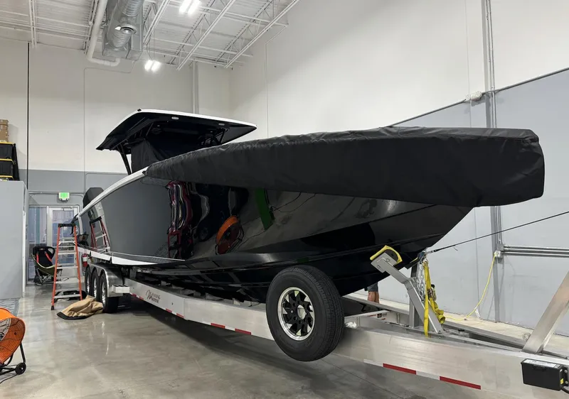 Slide: The Image of 2023 Nor-Tech 390 Sport Center Console boat on trailer in indoor storage. - 14