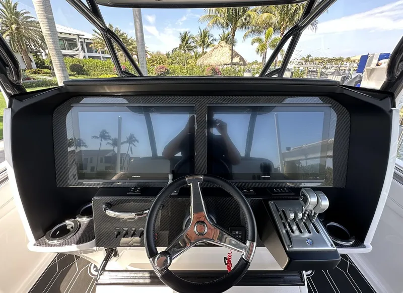 Slide: The Image of 2023 Nor-Tech 390 Sport Center Console dashboard with dual screens and steering wheel. - 4