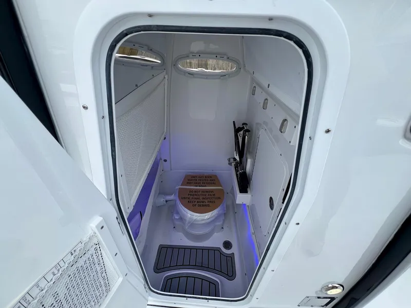 Slide: The Image of 2025 Sea Hunt Gamefish 27 boat interior with compact marine toilet. - 13