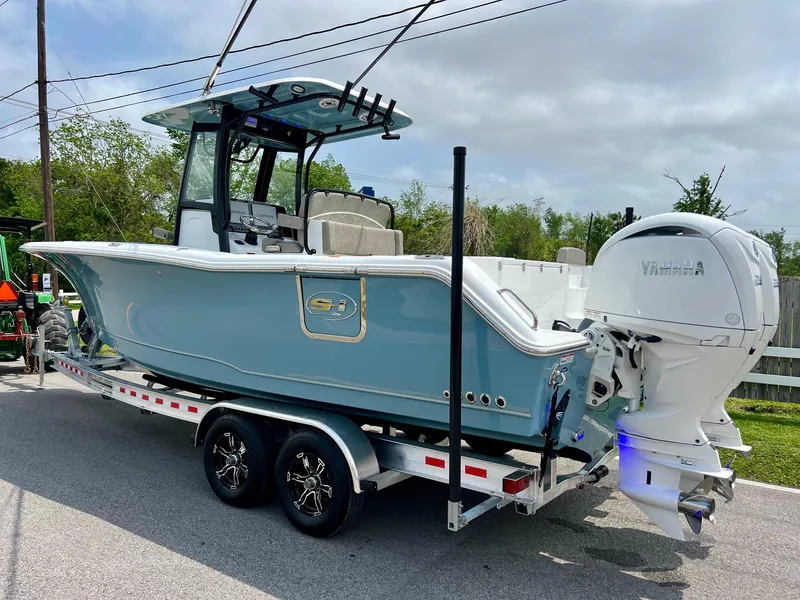 Slide: The Image of 2025 Sea Hunt Gamefish 27 with Coffin Box on trailer, featuring Yamaha outboard engines. - 2