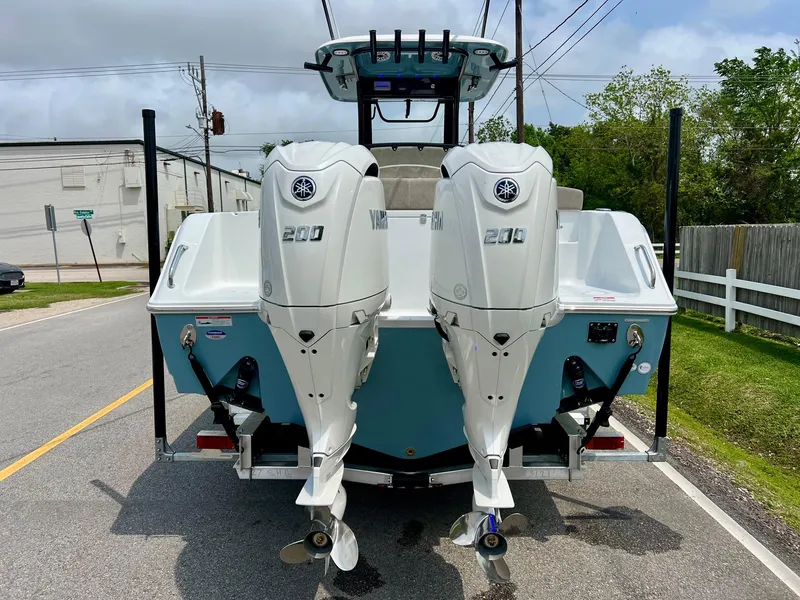 Slide: The Image of 2025 Sea Hunt Gamefish 27 with Coffin Box, dual Yamaha 200 engines, rear view on street. - 3