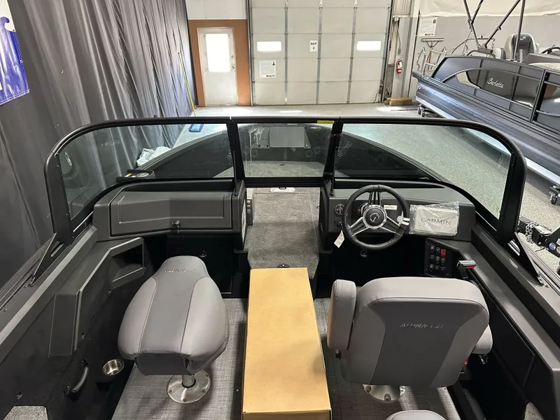 Slide: The Image of 2025 Alumacraft Competitor 185X Sport interior with steering wheel and seating in a showroom. - 11