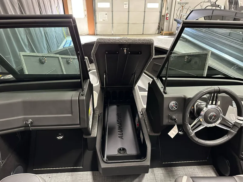 Slide: The Image of 2025 Alumacraft Competitor 185X Sport interior with open storage and steering wheel. - 14