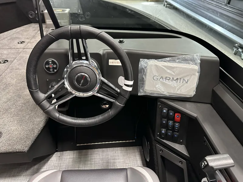 Slide: The Image of 2025 Alumacraft Competitor 185X Sport dashboard with steering wheel and Garmin navigation system. - 17