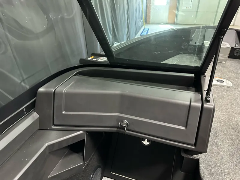 Slide: The Image of 2025 Alumacraft Competitor 185X Sport boat interior with windshield and storage compartment. - 19