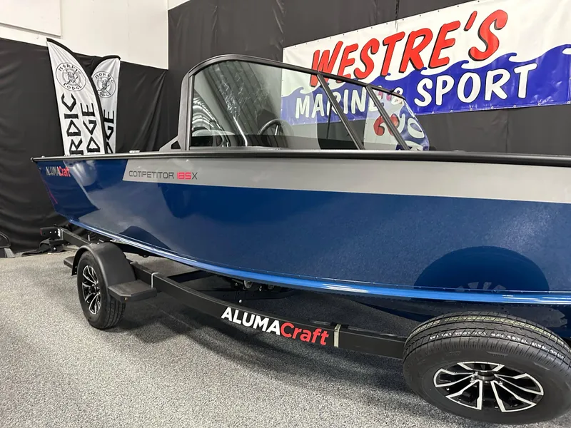 Slide: The Image of 2025 Alumacraft Competitor 185X Sport boat displayed at Westre's Marine and Sport showroom. - 2