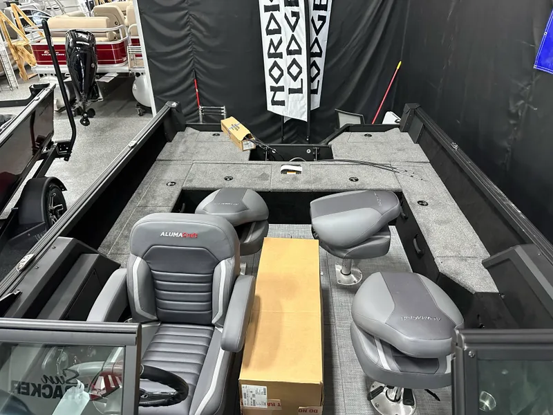 Slide: The Image of 2025 Alumacraft Competitor 185X Sport boat interior with gray seating and Nordic Lodge banner. - 21