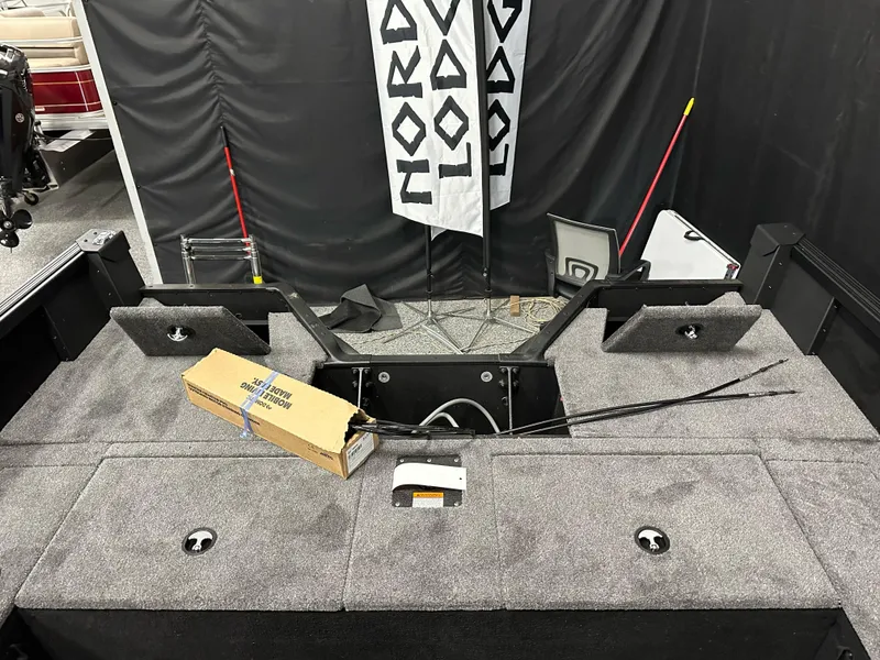 Slide: The Image of 2025 Alumacraft Competitor 185X Sport boat interior with storage compartments and fishing gear. - 23