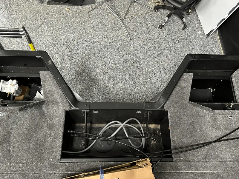 Slide: The Image of 2025 Alumacraft Competitor 185X Sport interior, showcasing storage compartments and wiring setup. - 24