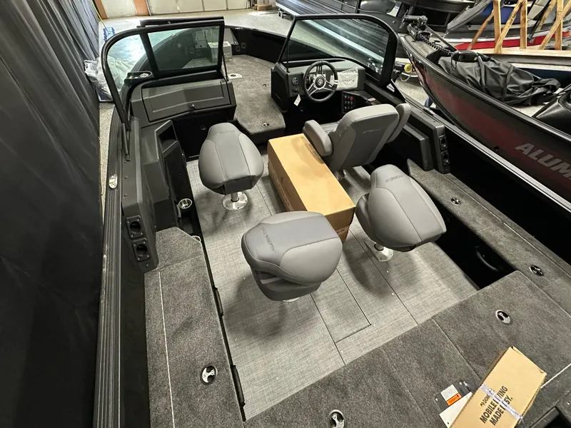 Slide: The Image of 2025 Alumacraft Competitor 185X Sport boat interior with gray seating and steering console. - 26