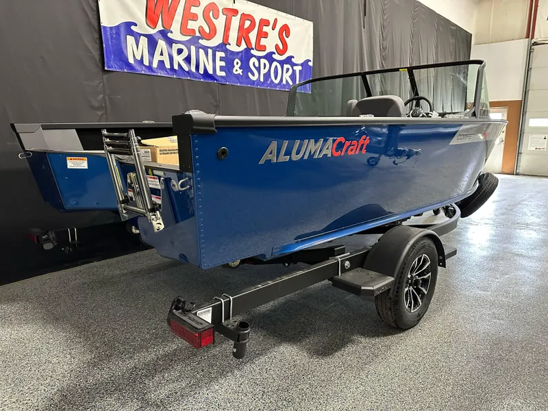 Slide: The Image of 2025 Alumacraft Competitor 185X Sport boat in showroom, blue color, on trailer. - 3