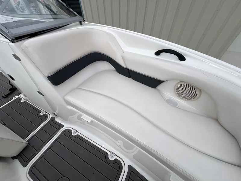 Slide: The Image of 2007 Yamaha Boats SX210 interior seating with white upholstery and integrated speaker. - 14