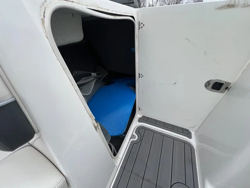 Slide: The Image of Open storage compartment on 2007 Yamaha SX210 boat, showing interior space and items. - 25