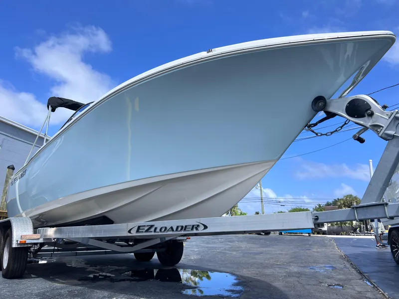 Slide: The Image of 2025 Key West 203 DFS boat on EZ Loader trailer under clear blue sky. - 8
