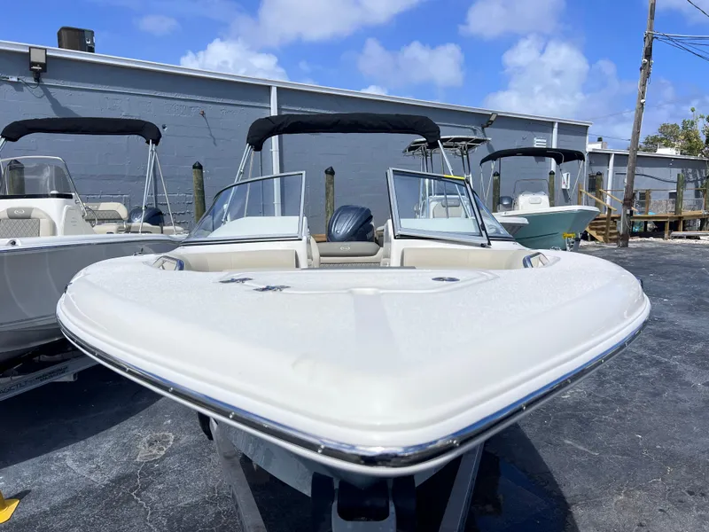 Slide: The Image of 2025 Key West 203 DFS boat with dual consoles, parked outdoors under a clear blue sky. - 9