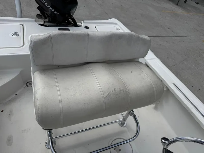 Slide: The Image of 2007 Triton 240 LTS boat seat with white upholstery and metal frame. - 11