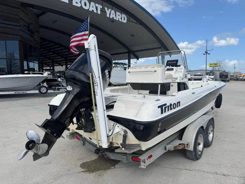 Slide: The Image of 2007 Triton 240 LTS boat on trailer at a boat yard, featuring an outboard motor. - 6
