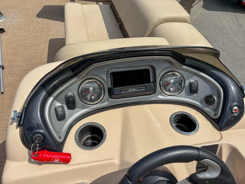 Slide: The Image of 2019 Sun Tracker Fishin Barge 24 DLX dashboard with gauges and cup holders. - 11