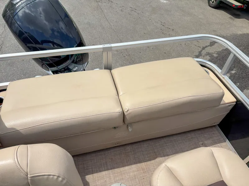 Slide: The Image of 2019 Sun Tracker Fishin Barge 24 DLX with beige seating and visible outboard motor. - 13