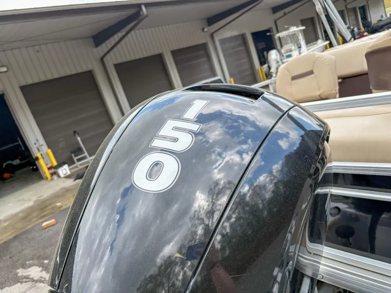 Slide: The Image of Outboard motor on 2019 Sun Tracker Fishin Barge 24 DLX, reflecting sky and clouds. - 16