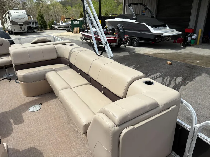 Slide: The Image of 2019 Sun Tracker Fishin Barge 24 DLX with beige seating in a marina setting. - 6