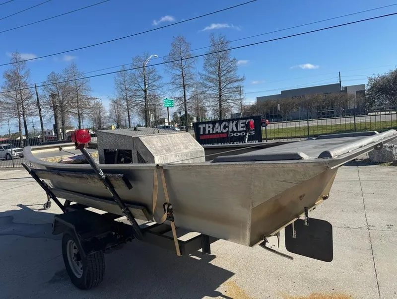 Slide: The Image of 1984 Custom Inboard Mud Boat on trailer, parked outdoors under clear sky. - 6