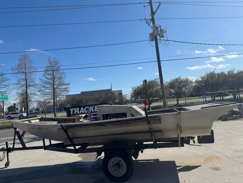 Slide: The Image of 1984 Custom Inboard Mud Boat on trailer under clear blue sky. - 7