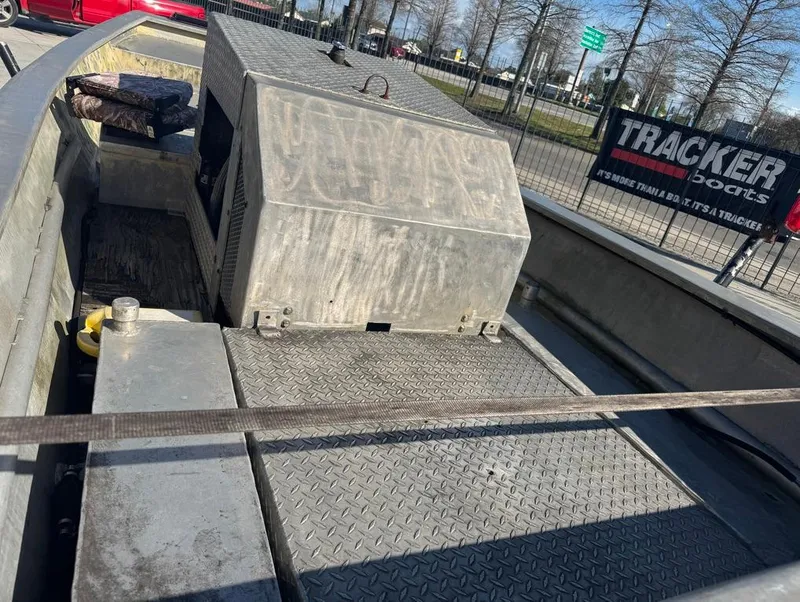 Slide: The Image of 1984 Custom Inboard Mud Boat with metal deck and engine cover, parked outdoors. - 8
