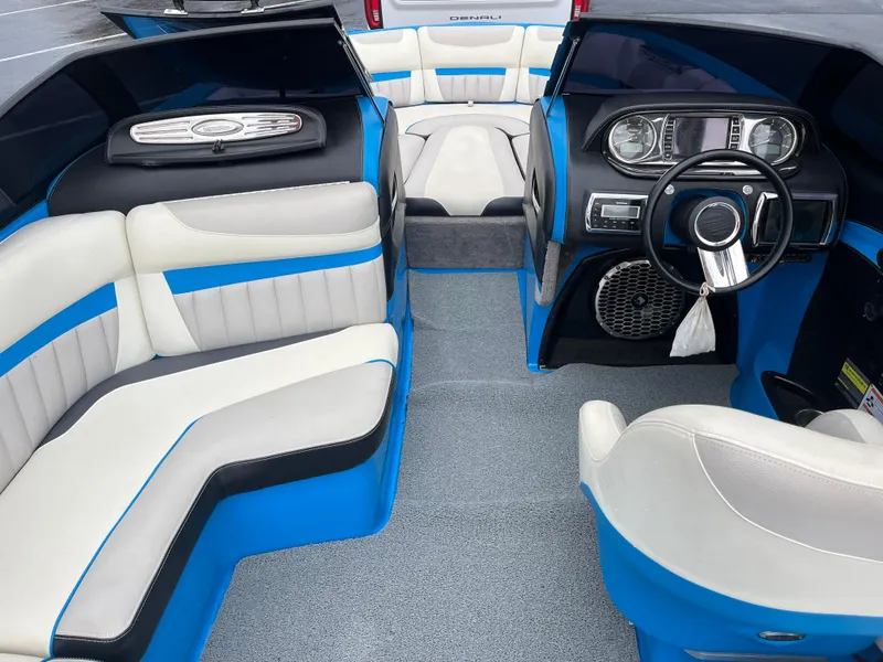Slide: The Image of 2014 Malibu Wakesetter 24 MXZ interior with blue and white seating, modern dashboard, and spacious layout. - 4