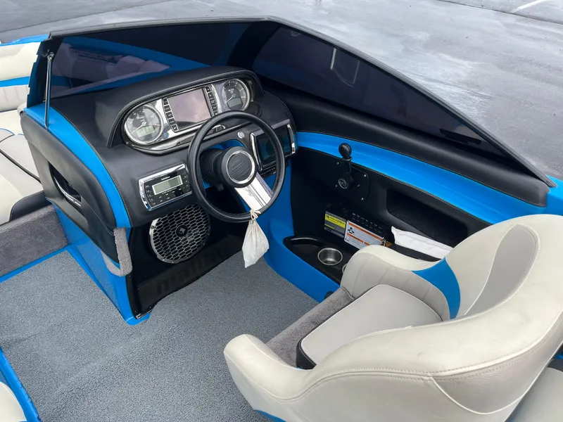 Slide: The Image of 2014 Malibu Wakesetter 24 MXZ boat interior with blue accents and modern dashboard. - 5