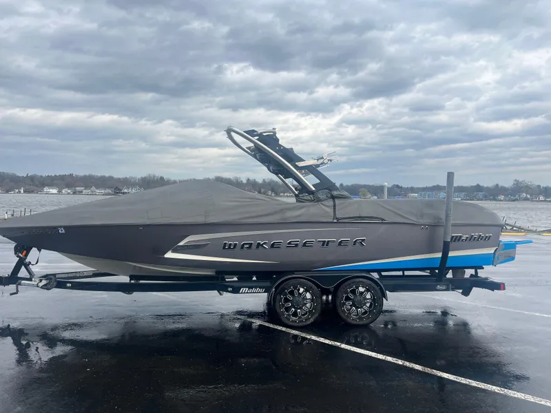 Slide: The Image of 2014 Malibu Wakesetter 24 MXZ boat on trailer under cloudy sky. - 7