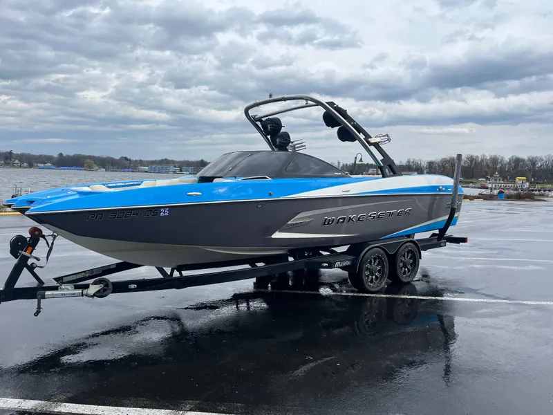 Slide: The Image of 2014 Malibu Wakesetter 24 MXZ boat on trailer, parked on wet pavement. - 8