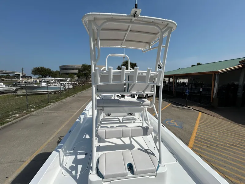 Slide: The Image of 2025 Shallow Sport 25 X3 boat with elevated seating and canopy in a marina setting. - 10