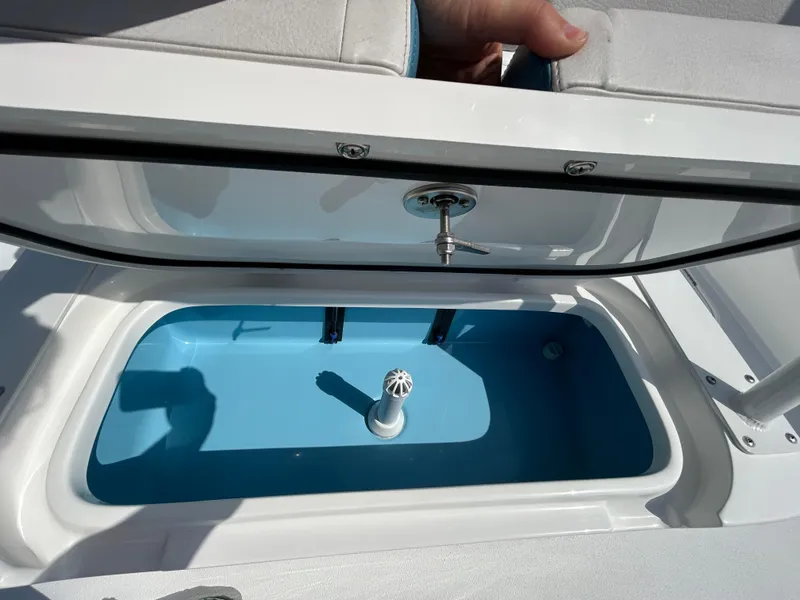 Slide: The Image of Livewell compartment on 2025 Shallow Sport 25 X3 boat, open lid, blue interior. - 11