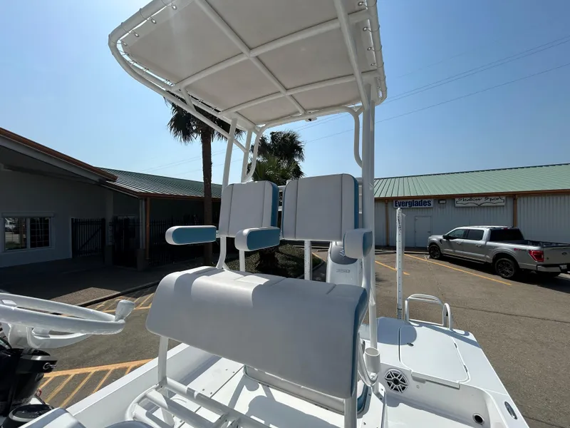 Slide: The Image of 2025 Shallow Sport 25 X3 boat with elevated seating and canopy in a parking lot. - 16