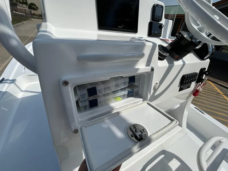 Slide: The Image of 2025 Shallow Sport 25 X3 boat console with storage compartment and steering wheel. - 17