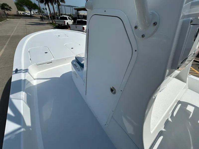 Slide: The Image of 2025 Shallow Sport 25 X3 boat deck with console, parked outdoors. - 18
