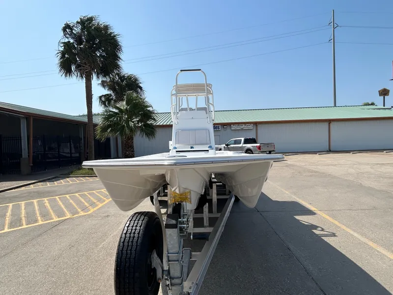 Slide: The Image of 2025 Shallow Sport 25 X3 boat on trailer, parked outdoors near palm trees. - 2