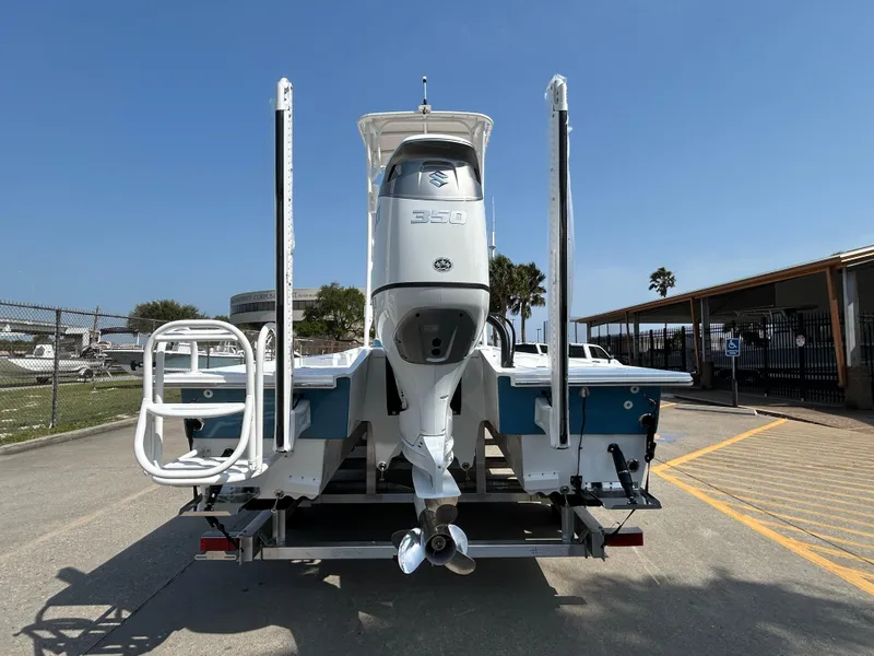 Slide: The Image of 2025 Shallow Sport 25 X3 boat, rear view with outboard motor, parked outdoors. - 3