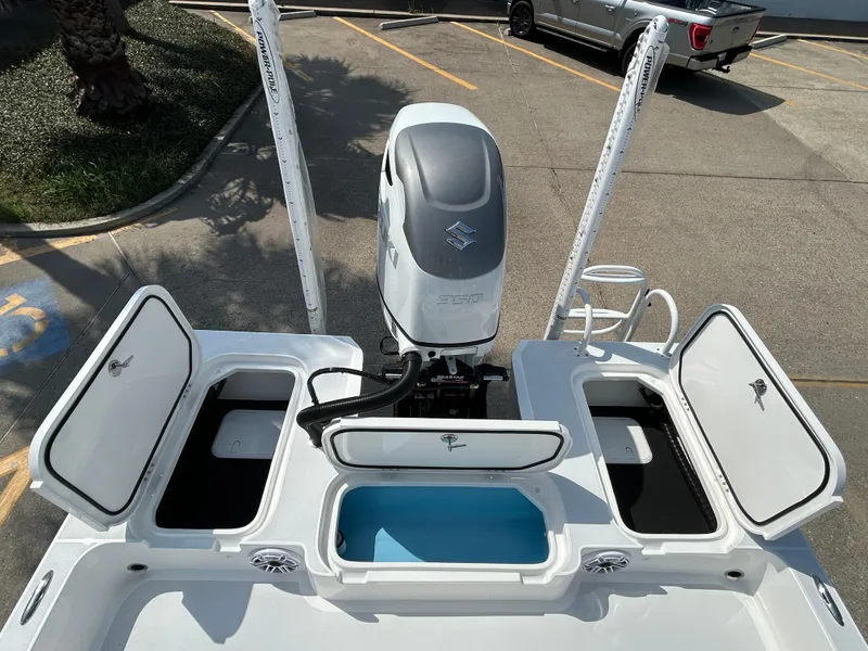 Slide: The Image of 2025 Shallow Sport 25 X3 boat with open storage compartments and outboard motor. - 9